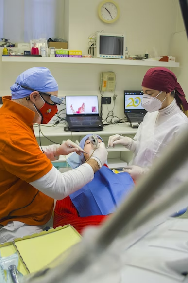 a dentist and a dental staff working together to work on a patient's dental procedure
