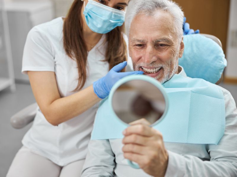 A patient admiring their new dental implants in Addison, TX